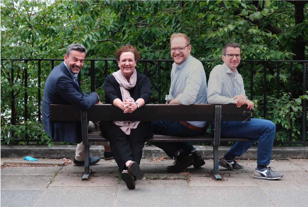 Image of a group of people sat on a bench